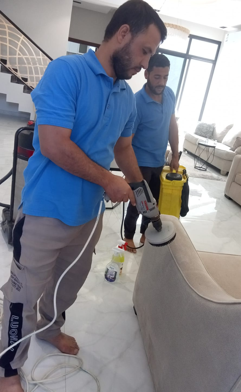 فني متخصص يعتني بتنظيف أريكة في منزل بالرياض