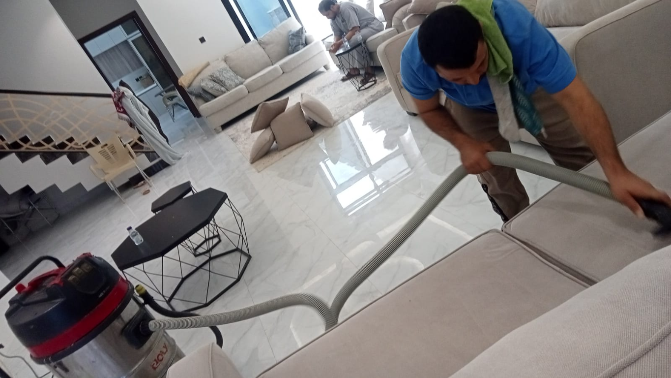 فريق العمل أثناء تنظيف الأريكة